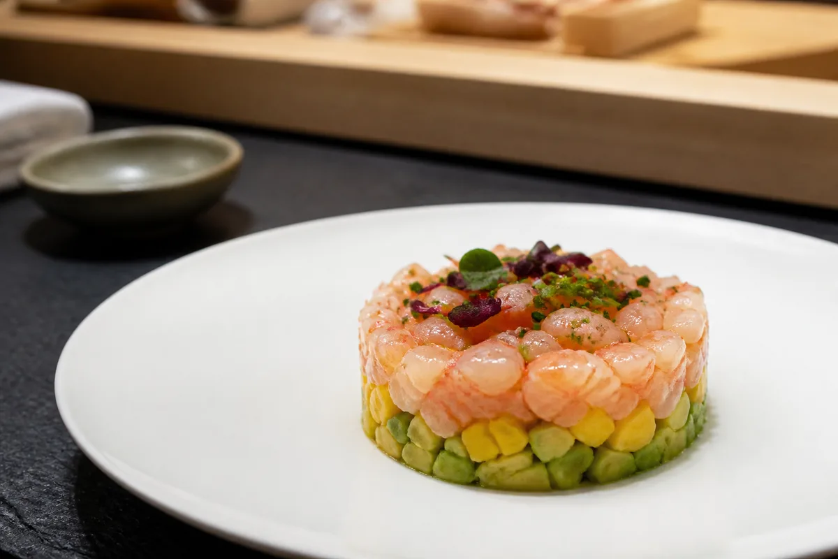 Tartare de crevette, avocat et mangue monté au cercle sur une assiette blanche
